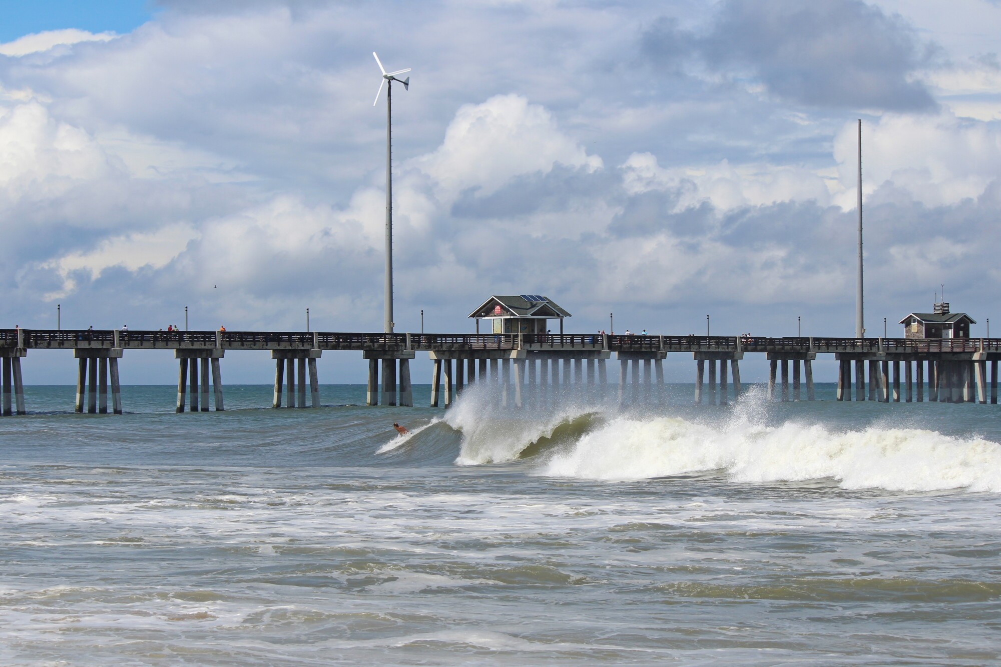 the-outer-banks a close up of a pier next to a body of water