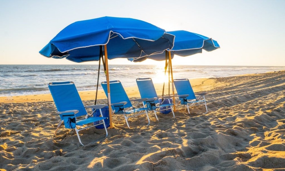 a couple of lawn chairs sitting on top of a beach