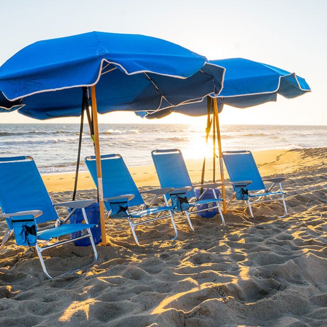 Farmdog Beach Serivcies lawn chairs sitting on top of a beach