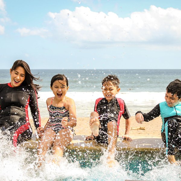 kids splashing water on a sandy beach