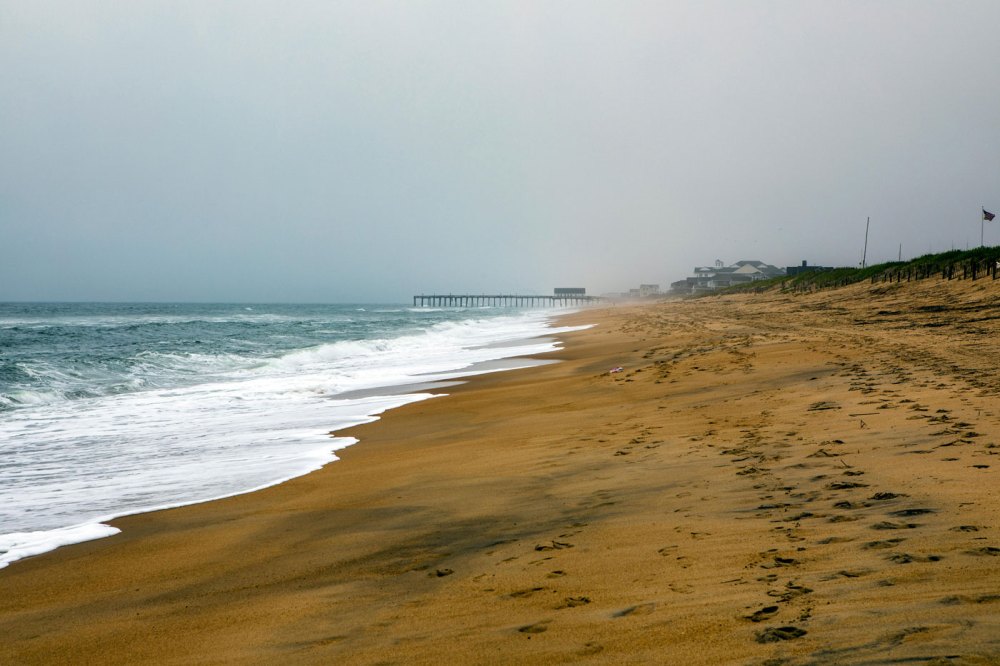 a sandy beach next to a body of water