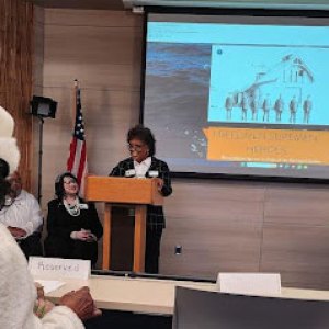 a group of people sitting at a table in front of a television