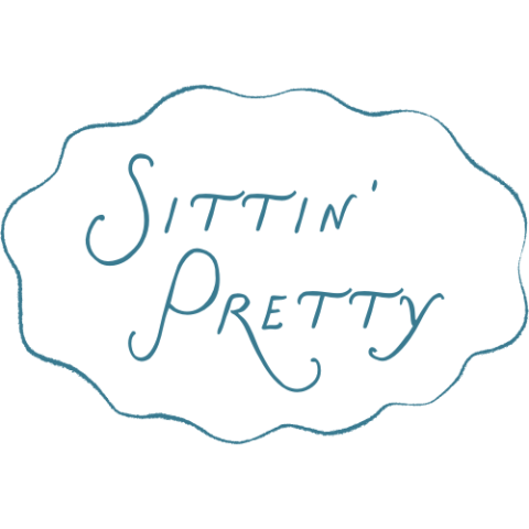 Elegant blue script text 'Sittin' Pretty' inside a decorative scalloped border on white background.